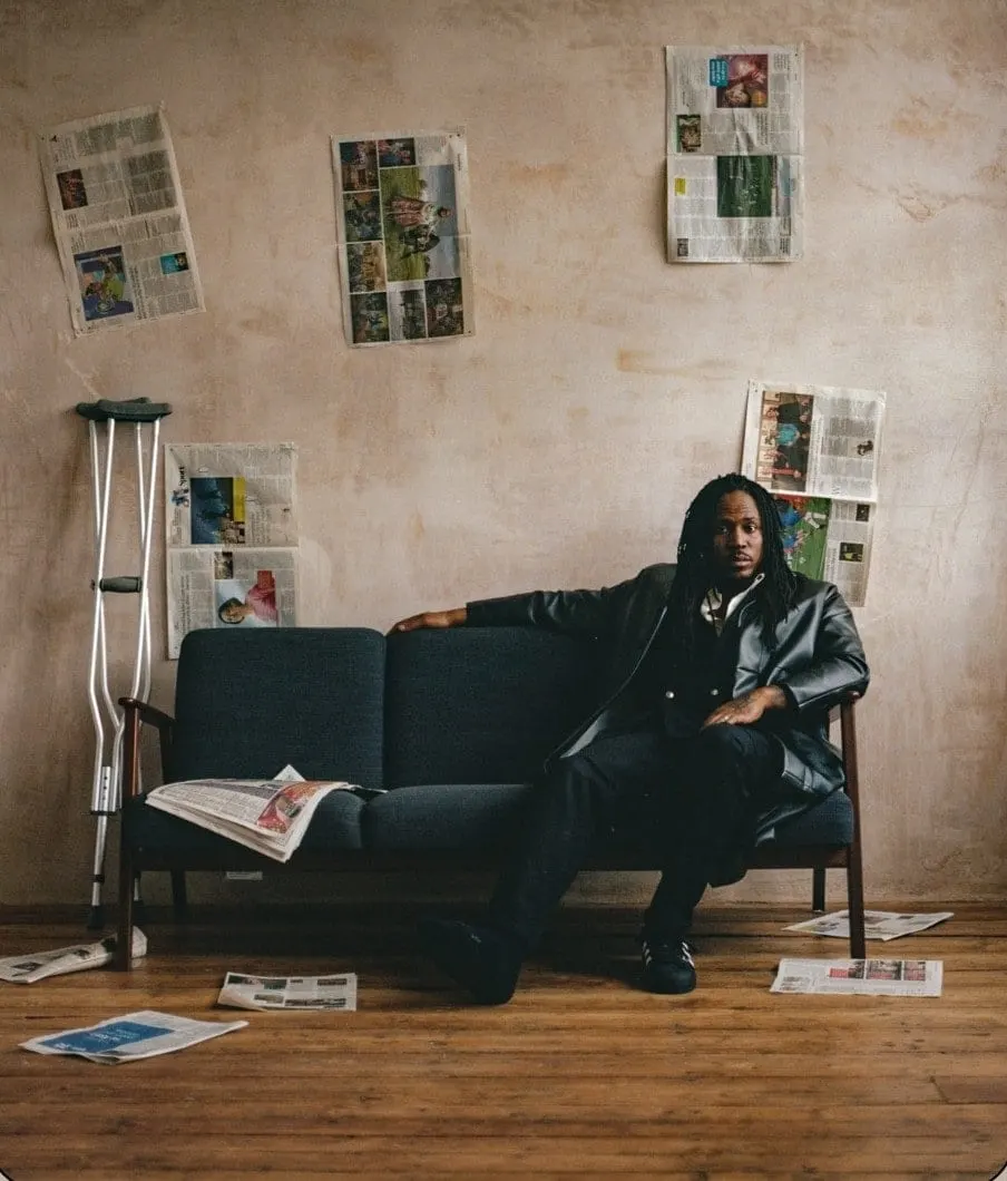SiR on a sofa in a room papered with newsprint
